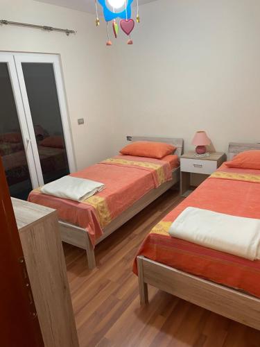 a bedroom with two beds and a mirror at Villa Mimoza in Golem