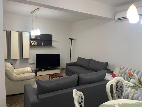 een woonkamer met een bank en een tv bij Villa Mimoza in Golem