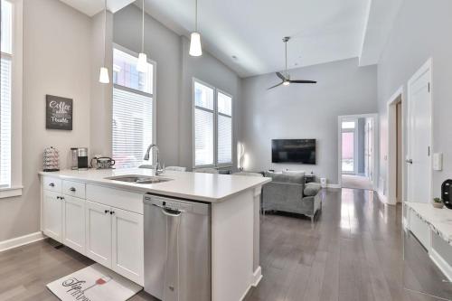 a white kitchen with a sink and a living room at **NEW mOdernLUX best OTR condo *Park ONsite** in Cincinnati