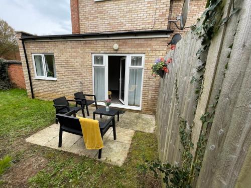 a patio with chairs and a table in front of a building at One Bed Apartment Stevenage in Stevenage