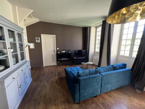 un salon avec un canapé bleu et une table dans l'établissement La Maison d'Albusse, à Sarlat-la-Canéda