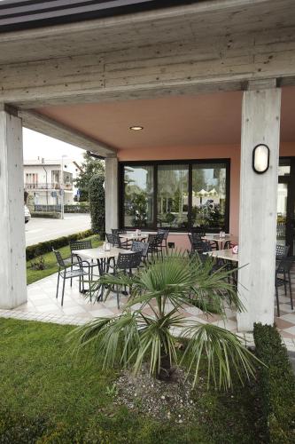 a patio with tables and chairs and a clock at Hotel Ganfo in Sirmione