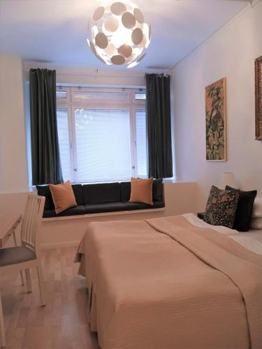 a bedroom with two beds and a couch in front of a window at Hotel Hornsgatan in Stockholm