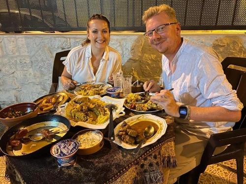 a man and woman sitting at a table with food at Petra View Flat in Wadi Musa