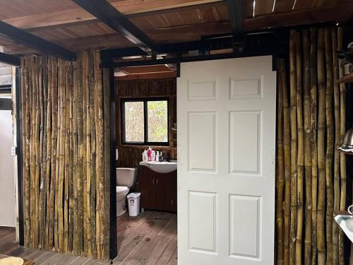 ein Bad mit einem WC und einer weißen Tür in der Unterkunft Aqeel cabin in the nature in Penonomé
