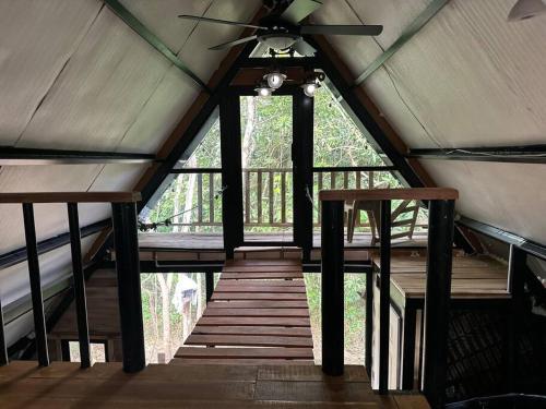 um quarto com uma ventoinha de tecto e piso em madeira em Aqeel cabin in the nature em Penonomé