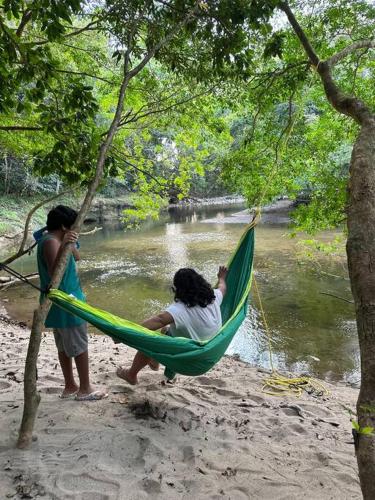 two people in a hammock next to a river at Aqeel cabin in the nature in Penonomé