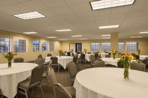 a conference room with tables and chairs with flowers on them at GreenTree Inn & Suites Phoenix Sky Harbor in Phoenix