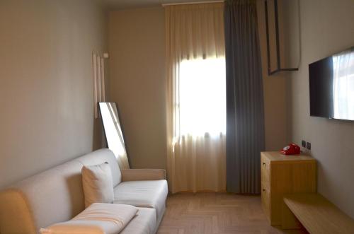 a living room with a white couch and a window at RE Versiliana Junior-House in Marina di Pietrasanta
