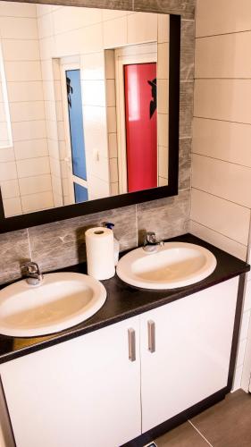 a bathroom with two sinks and a mirror at Hotel Amicus in Mostar