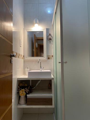 y baño con lavabo y espejo. en Apto Master de 2 quartos a 100m do Mar, central, en Balneário Camboriú