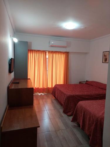 a hotel room with two beds and a window at Tajy Iguazu Hotel in Puerto Iguazú