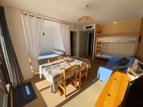 Cette chambre comprend une table, un canapé et un lit. dans l'établissement Studio cosy 4 pers. avec balcon sud, départ ski aux pieds, navette gratuite, à 600m des commerces - FR-1-417-8, à La Toussuire