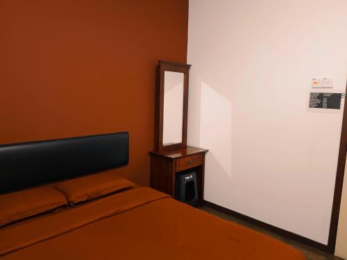 a bedroom with a bed and a mirror on the wall at BMW Hotel in Muar