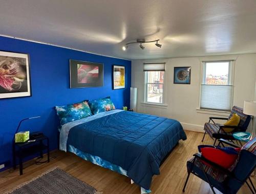 a blue bedroom with a bed and a blue wall at Unique Artsy 2 Bdrm Apt 1.5 mi from Downtown in Pittsburgh