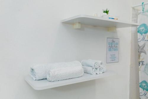 uma prateleira branca com toalhas numa parede branca em 3BR spacious, dorado beach apartment, -20% monthly em Dorado