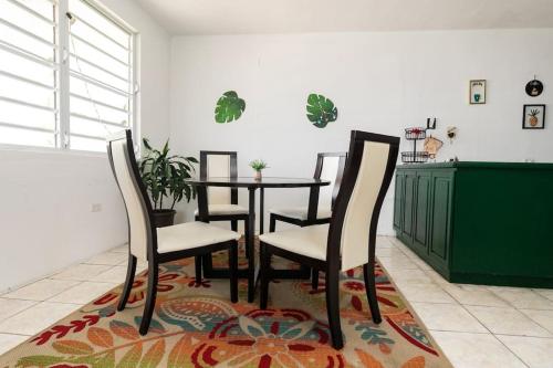 a dining room with a table and chairs on a rug at 3BR spacious, dorado beach apartment, -20% monthly in Dorado