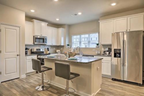 a kitchen with white cabinets and a stainless steel refrigerator at Modern Townhome 10 mins to Downtown Atlanta in Atlanta
