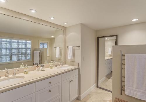 a bathroom with two sinks and a large mirror at 3884 Twenty-One Oaks home in Carmel