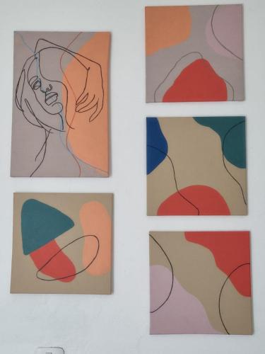 four paintings on a white wall at The Wabi Sabi in León