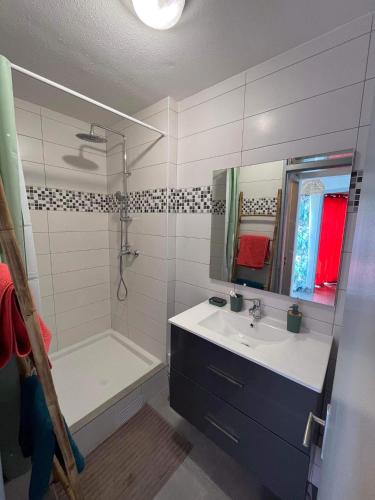 a bathroom with a sink and a shower and a tub at La Kaz Vert d’Õ in Saint-Denis