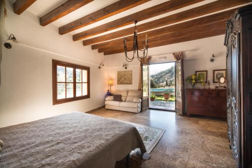 a bedroom with a bed and a living room at Hotel Sa Vall in Valldemossa