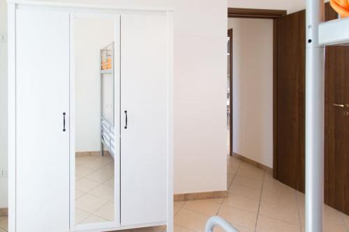 a closet with white doors in a room at Apartment kite - Stagnone villaggio solaris in Marsala