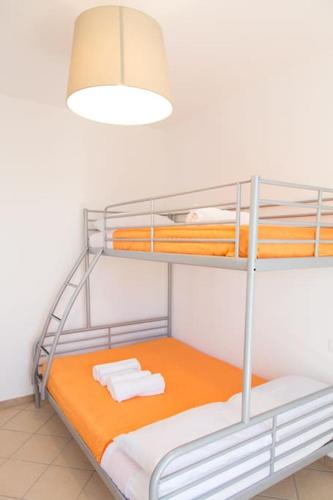 a bunk bed with an orange mattress and a light at Apartment kite - Stagnone villaggio solaris in Marsala