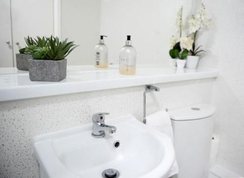 a white bathroom with a sink and a toilet at King's Central Cambridge Apartment in Cambridge
