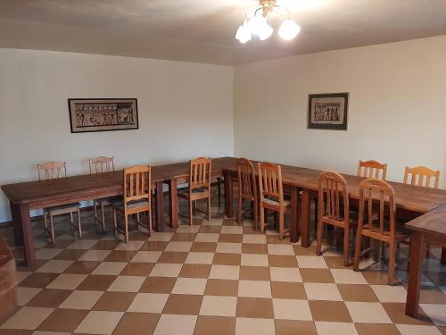 uma sala de jantar com uma mesa longa e cadeiras em Ezernieki em Valka