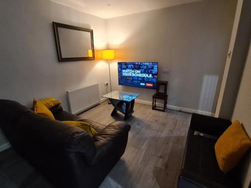 a living room with a couch and a flat screen tv at Whole House - 4 Bedrooms - Parking - Sleeps 8 in Birmingham