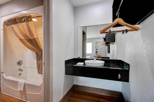 a bathroom with a sink and a tub and a mirror at Motel 6-Port Allen, LA - Baton Rouge in Port Allen