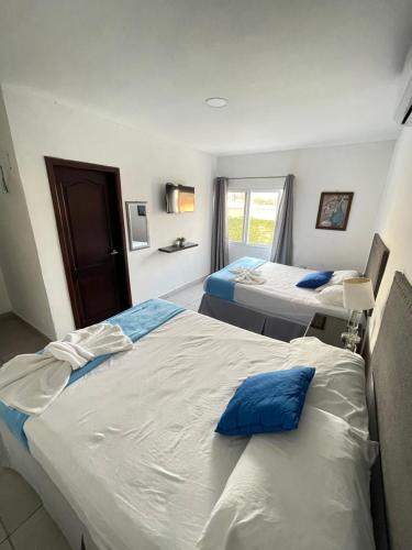 a hotel room with two beds and a window at Hotel Boutique Los Pinos in Santa Rosa de Copán