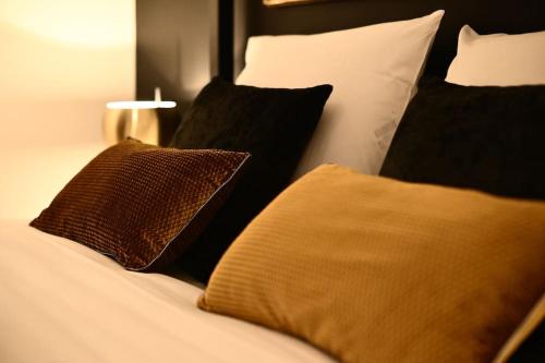 - un lit avec des oreillers en noir et blanc dans l'établissement DAUPHINE 2 - HYPERCENTRE HISTORIQUE DE DIJON, à Dijon