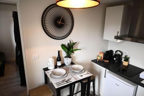 une petite cuisine avec une table et une horloge murale dans l'établissement DAUPHINE 2 - HYPERCENTRE HISTORIQUE DE DIJON, à Dijon
