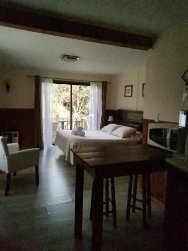 a bedroom with a bed and a table and a window at Departamento Rossbach in Puerto Puyuhuapi