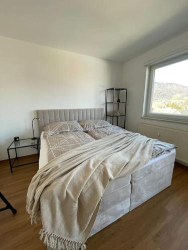 uma cama num quarto branco com uma janela em Sonniges Apartment mit Balkon em Graz