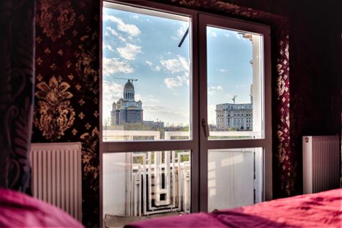 a bedroom window with a view of a city at Parliament Merlot Unirii Square 5 Bedrooms Luxury Apartment Old Town in Bucharest