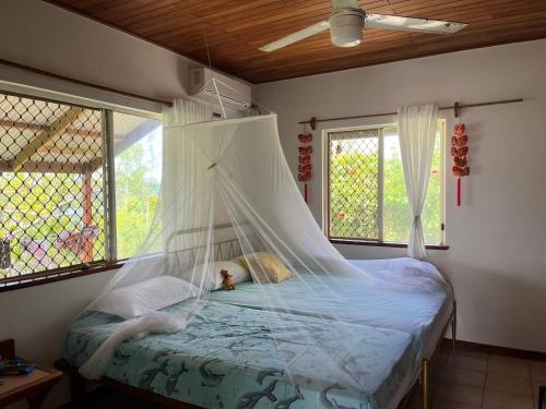 a bedroom with a bed with a mosquito net at TRADEWINDS VILLAS in Port Vila