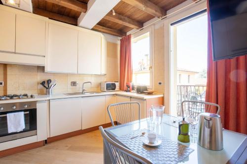 a kitchen with a table with chairs and a window at BolognaRoomscom - Santo Stefano Apartments in Bologna
