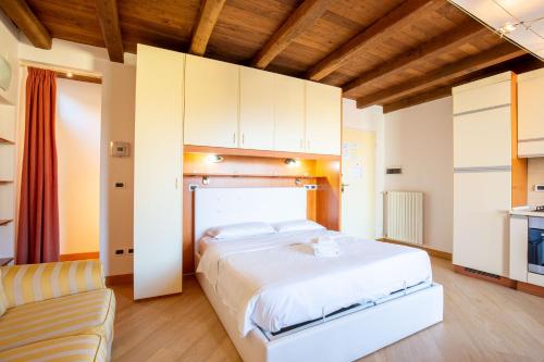 a bedroom with a large white bed and a couch at BolognaRoomscom - Santo Stefano Apartments in Bologna