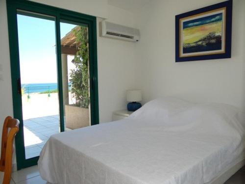 une chambre avec un lit et une vue sur l'océan dans l'établissement Superbe villa avec immense terrasse et vue sur mer, à 200m des plages - 2 chambres climatisées - FR-1-100-172, à Cavalaire-sur-Mer