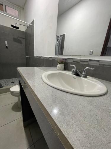 y baño con lavabo y aseo. en Hotel Boutique Los Pinos, en Santa Rosa de Copán