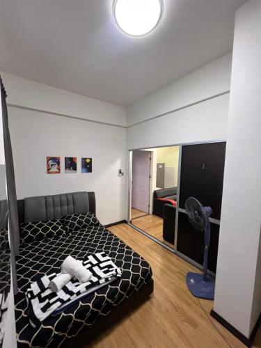サンダカンにあるKW HOMESTAY CASA UNO APARTMENTのベッドルーム1室(ベッド1台、ファン付)