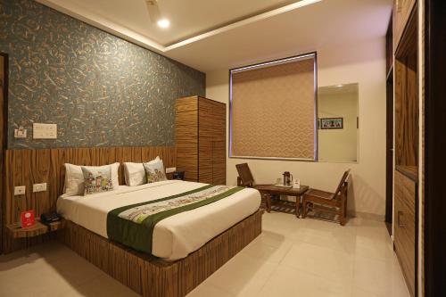 a bedroom with a bed and a table and a window at Super Capital O Hotel Swastika in Jaipur