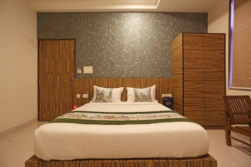 1 dormitorio con 1 cama grande y pared de madera en Capital O Swastika, en Jaipur