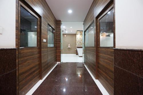 a hallway with wood paneled walls and a bathroom at Super Capital O Hotel Swastika in Jaipur