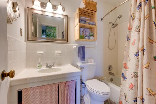 a bathroom with a sink and a toilet and a mirror at Vibrant Pass Christian Oasis - 3 Blocks to Beach! in Pass Christian