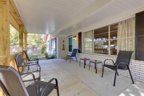 a porch with chairs and tables on a building at Vibrant Pass Christian Oasis - 3 Blocks to Beach! in Pass Christian