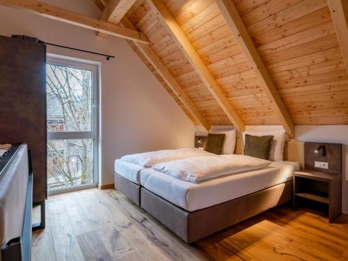 a large bed in a room with a large window at Mountain Chalet Arnica in Sankt Lorenzen ob Murau